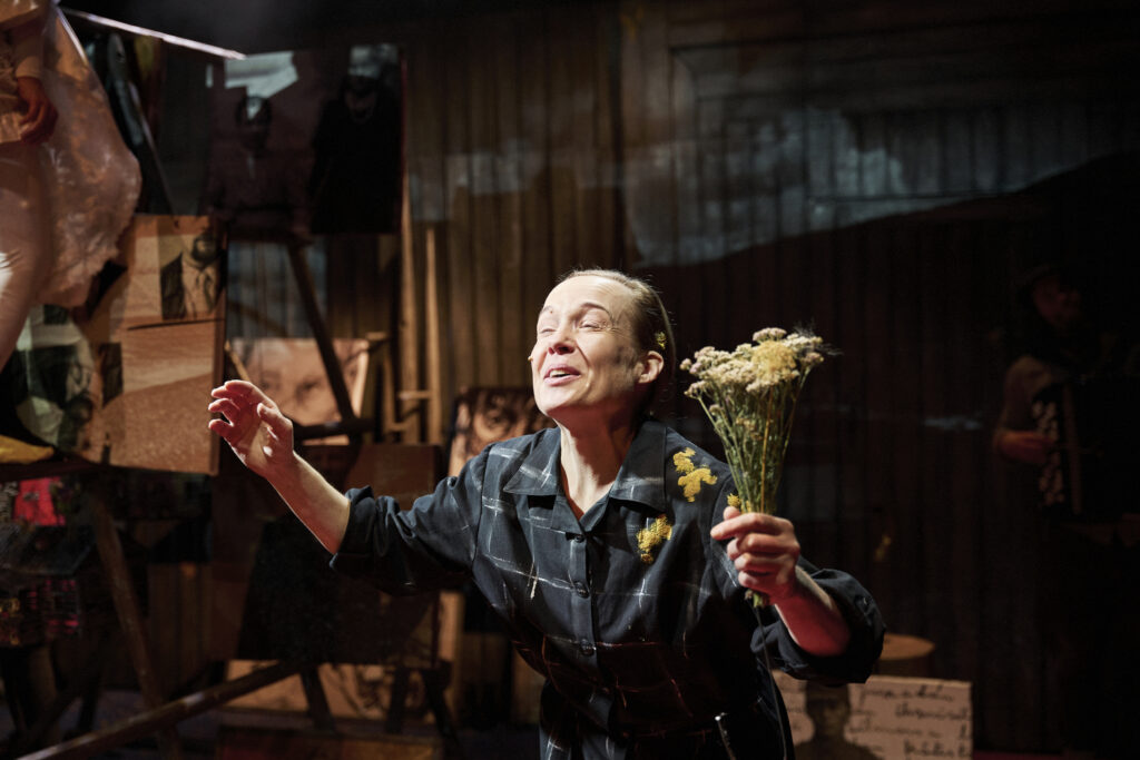 Näyttelijä hymuilee kukkakimppu kädessä